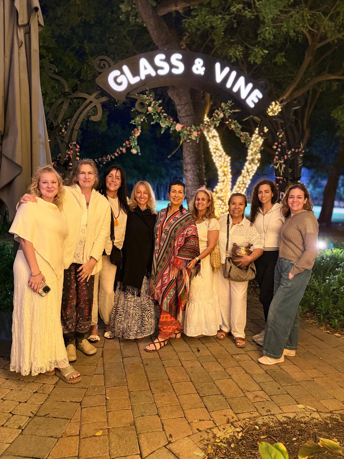 Diana and classmates gathered together at night under the Glass & Vine archway