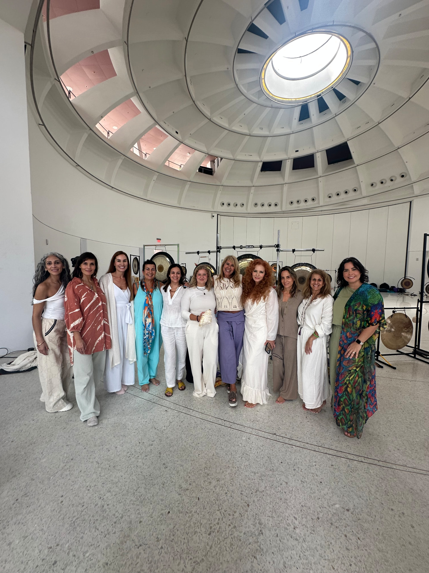 A circle of gong practitioners gathered under a bright domed ceiling after training